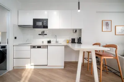 a kitchen with white cabinets and a table with chairs at Urban Quarters - Firuzağa in Istanbul