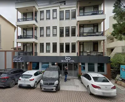 a building with cars parked in a parking lot at Brave otel in Darıca