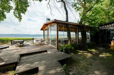 a wooden deck with a bench and a building at Meca Deluxe Otel Sapanca in Sapanca