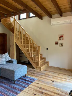 a living room with a wooden staircase and a couch at Lal Hayal Konakları in Sapanca