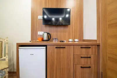 a kitchen with a refrigerator and a tv on a wall at İstanbulites Hotel in Istanbul