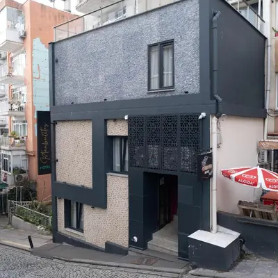 a black building with a doorway and a red car at İstanbulites Hotel in Istanbul