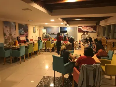 a group of people sitting at tables in a restaurant at Peri Pansiyon Butik Otel in Çınarcık