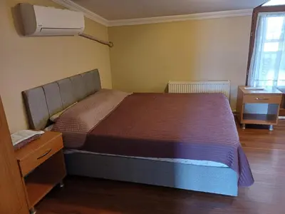a bedroom with a bed and a dresser and a window at Peri Pansiyon Butik Otel in Çınarcık