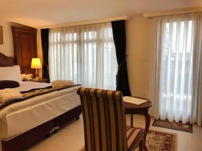 a bedroom with a bed and a table and a desk at GLK PREMIER Regency Suites & Spa in Istanbul