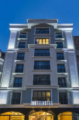 a tall white building with a sign on it at Inntel Hotel Istanbul in Istanbul