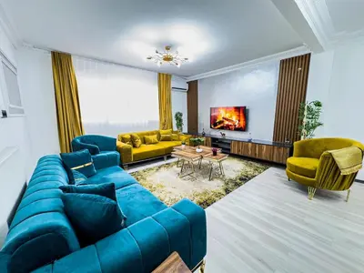 a living room with a blue couch and yellow chairs at Sisli Holiday 231 in Istanbul