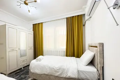 a bedroom with a bed and a yellow curtain at Sisli Holiday 231 in Istanbul