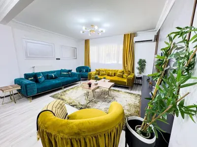 a living room with blue couches and yellow chairs at Sisli Holiday 231 in Istanbul