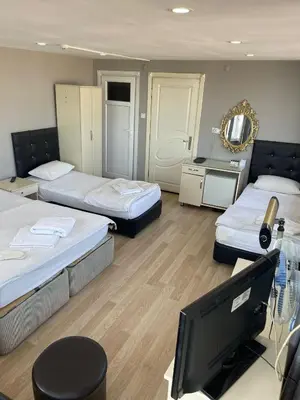 a room with two beds and a flat screen tv at SİMGE SULTAN' old cty in Istanbul