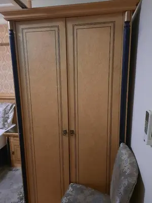 a wooden cabinet with two doors next to a chair at GRAND HiSAR HOTEL in Istanbul