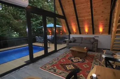 a living room with a couch and a pool at Köyevi Teras Bungolov in Kartepe