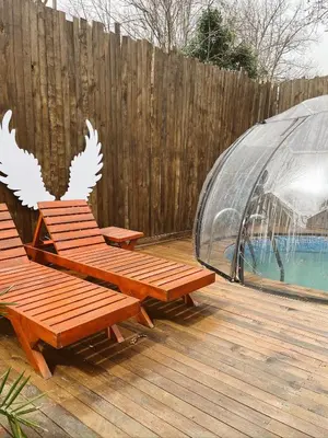 two wooden benches on a deck with a greenhouse at Wolf house in Sapanca