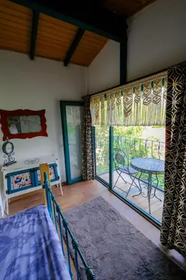 a bedroom with a bed and a table and a balcony at Aknadağevi sapanca in Sapanca
