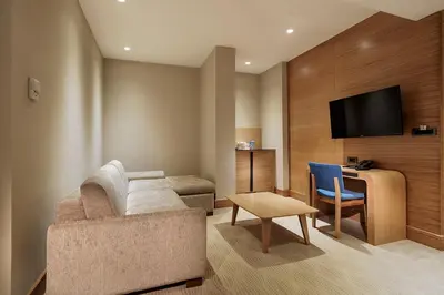 a living room with a couch and a table and a tv at DoubleTree by Hilton Hotel Istanbul - Tuzla in Istanbul