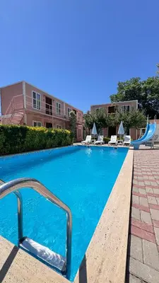 a blue swimming pool with a slide in a building at Ali Baba Butik Otel in Gündoğdu