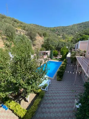 an image of a swimming pool in a garden at Ali Baba Butik Otel in Gündoğdu