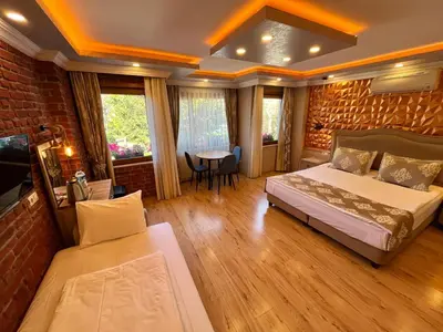 a bedroom with two beds and a table and a couch at Meydan Suites in Istanbul