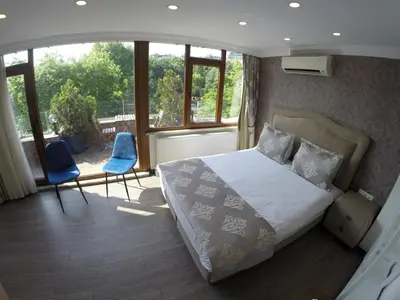a bedroom with a bed and two chairs and windows at Meydan Suites in Istanbul