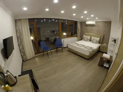 a bedroom with a bed and two blue chairs at Meydan Suites in Istanbul