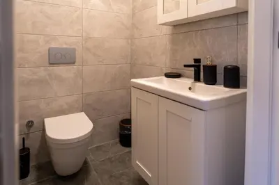 a bathroom with a white sink and a toilet at Luxury Scandinavian Design 2BR Duplex Near Tomtom in Istanbul