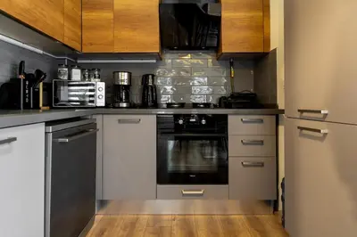 a kitchen with stainless steel appliances and wooden cabinets at Luxury Scandinavian Design 2BR Duplex Near Tomtom in Istanbul