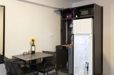 a small kitchen with a table and a refrigerator at Obishu in Istanbul