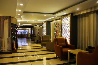 a lobby with chairs and tables and stained glass windows at Marmara Place Old City Hotel in Istanbul