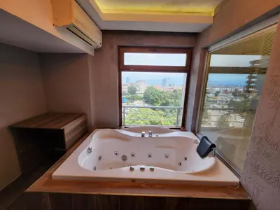 a large bath tub in a room with a window at Martin City Hotel in Bursa