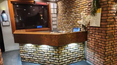 a brick wall with a counter with a window at Martin City Hotel in Bursa