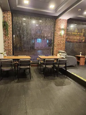 a restaurant with two tables and chairs and a couch at Martin City Hotel in Bursa