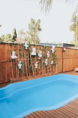 a wooden fence with a blue swimming pool at The Jungle Sapanca in Sakarya