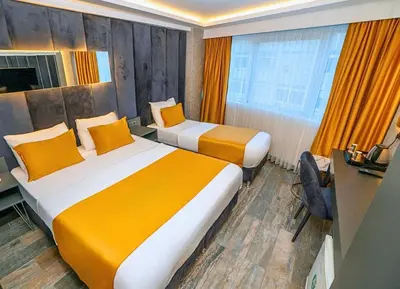 a hotel room with two beds and a desk at 216 Silver Suite in Tuzla