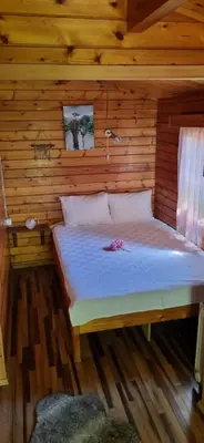 a bedroom with a bed in a wooden cabin at Çakıl Restoran ve Bungolov in Silivri