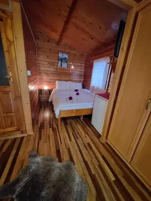 a bedroom with a bed in a wooden cabin at Çakıl Restoran ve Bungolov in Silivri
