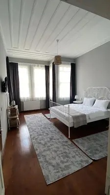 a bedroom with a white bed and a rug at DESTA Turizm in Istanbul