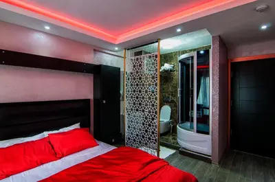 a bedroom with a red bed and a bath tub at AG Hotel & Residence Şişli in Istanbul