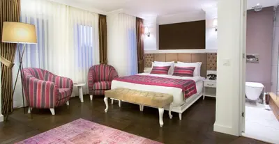 a hotel room with a bed and two chairs at Astan Hotel Taksim in Istanbul