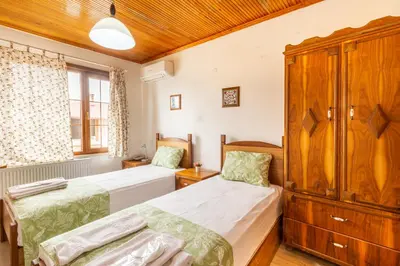 a bedroom with two beds and a cabinet at İznik Seyir Otel in İznik