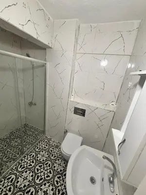 a white bathroom with a shower and a toilet at Studios & Balat in Istanbul
