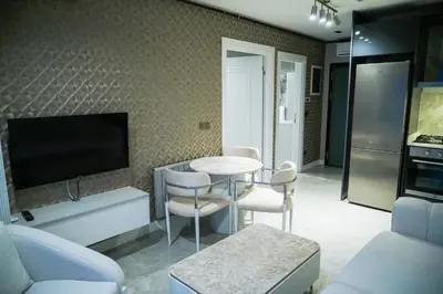 a living room with a table and chairs and a tv at Elite World Homes Istanbul Bosphorus in Istanbul