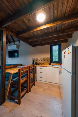 a kitchen with a refrigerator and a table in it at Varuna Bungalov Evleri in Sapanca