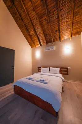a bedroom with a large bed with a wooden ceiling at Varuna Bungalov Evleri in Sapanca