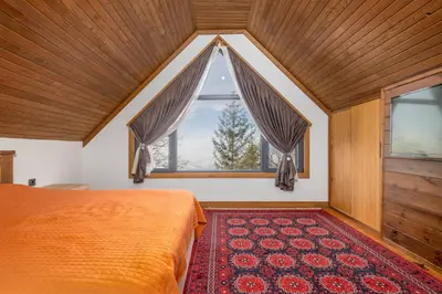 a bedroom with a bed and a large window at Uludağ Tatil Evleri & Villa Seyir in Yigitali