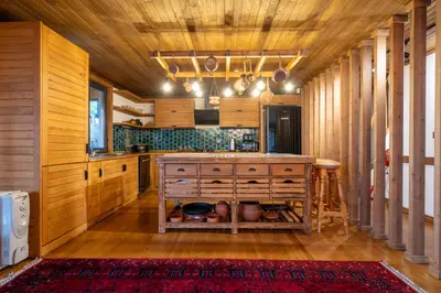 a kitchen with wooden cabinets and a large island at Uludağ Tatil Evleri & Villa Seyir in Yigitali