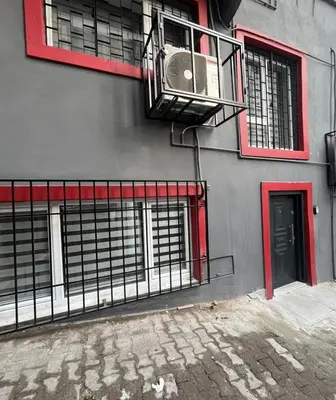 a building with red windows and a fan on it at Stunning 2BR 2Bath near Metro - YM 1 in Istanbul