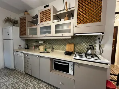 a kitchen with white cabinets and a stove top oven at Taksim Apartment in Istanbul