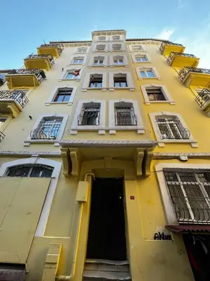 a tall yellow building with windows and a door at Taksim Apartment in Istanbul