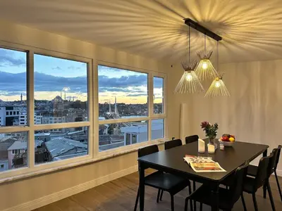 a dining room with a table and chairs and windows at Stunning 2BR 3AC Near Metro - YM 3 in Istanbul