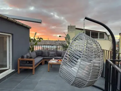 a patio with a couch and a swing on a balcony at Stunning Seaview 2BR near Metro - YM5 in Istanbul